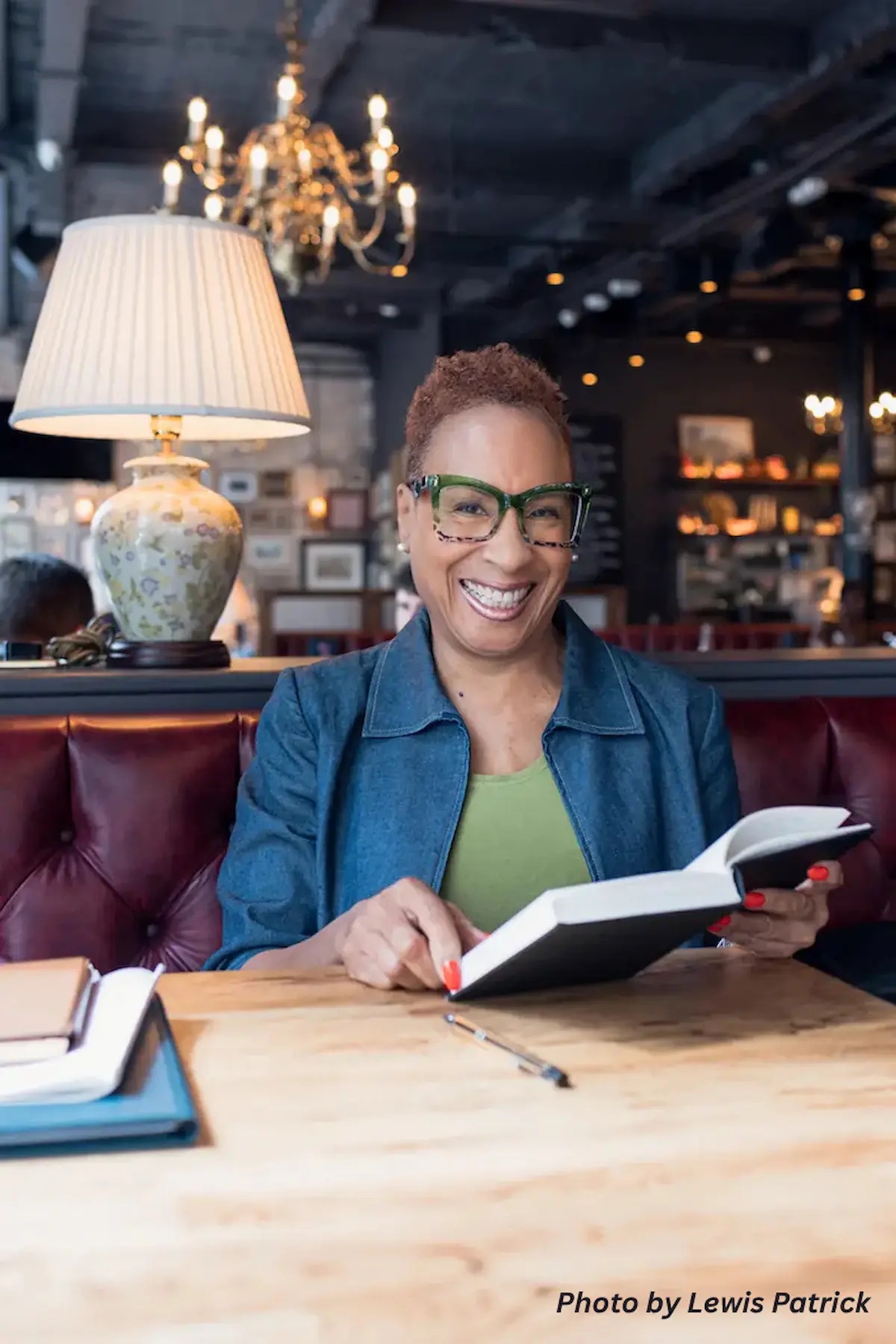 Meave Darroux smiling at a table with an open book