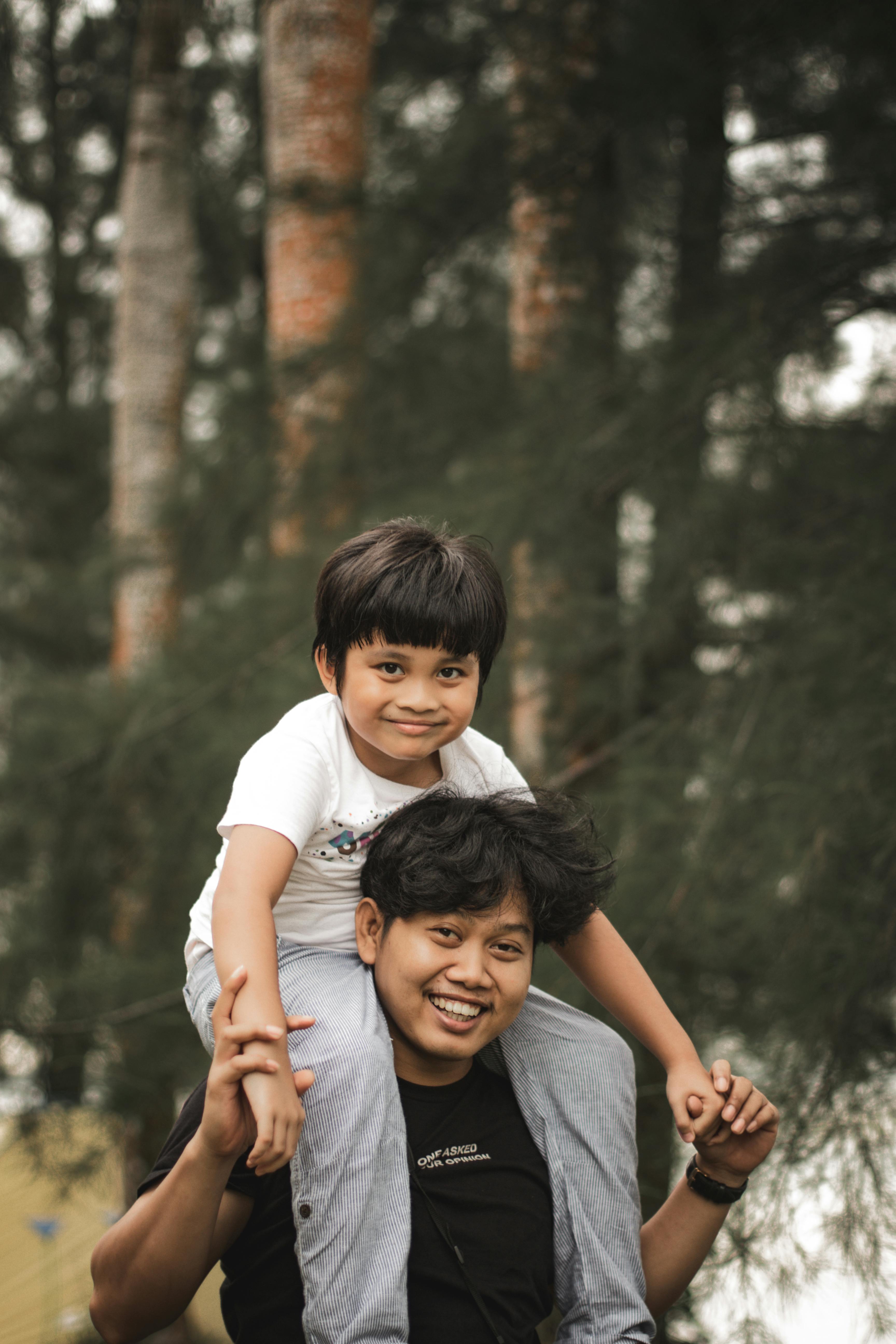 A father carrying his son on his shoulders in the park