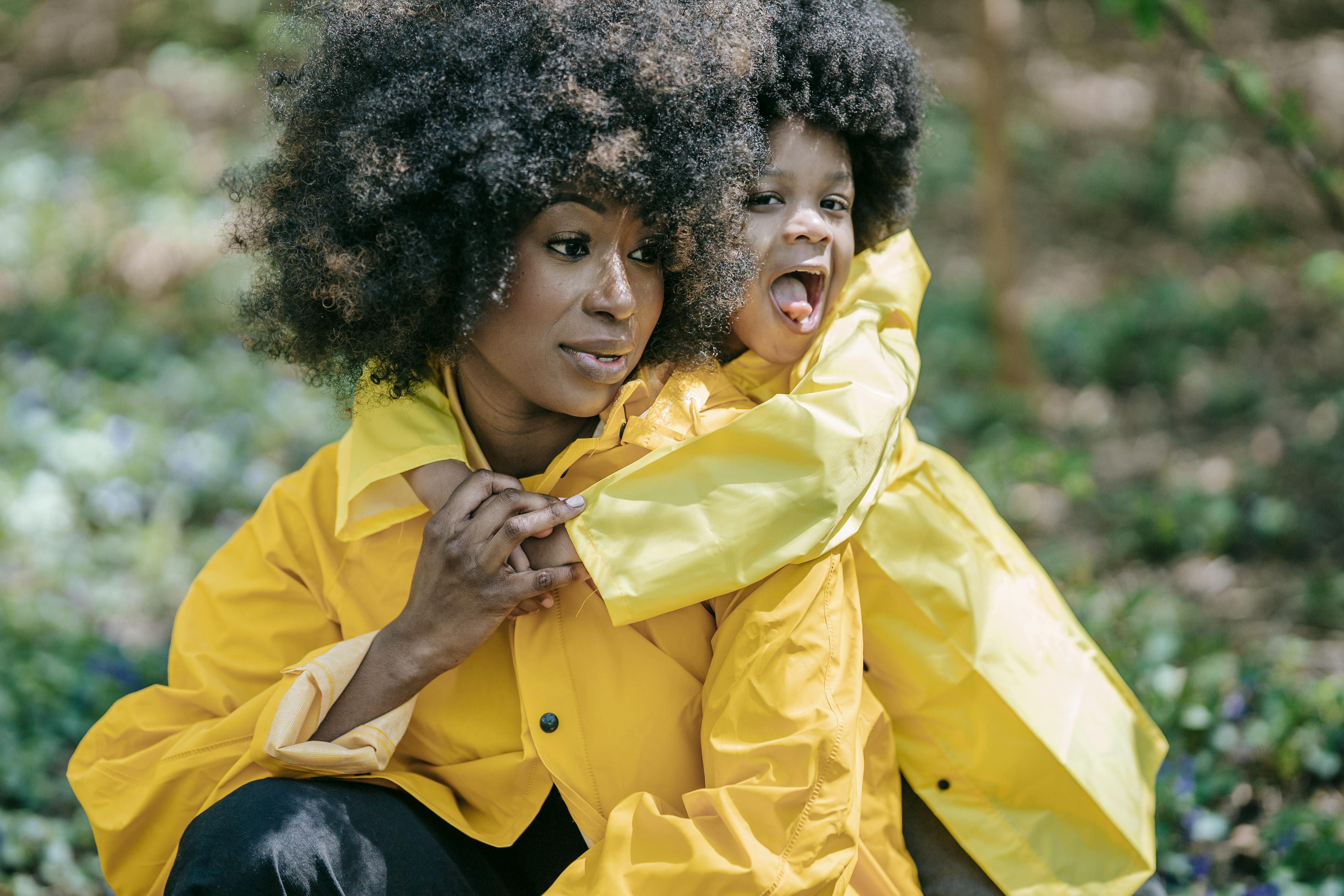 A smiling Black mother hugging her child